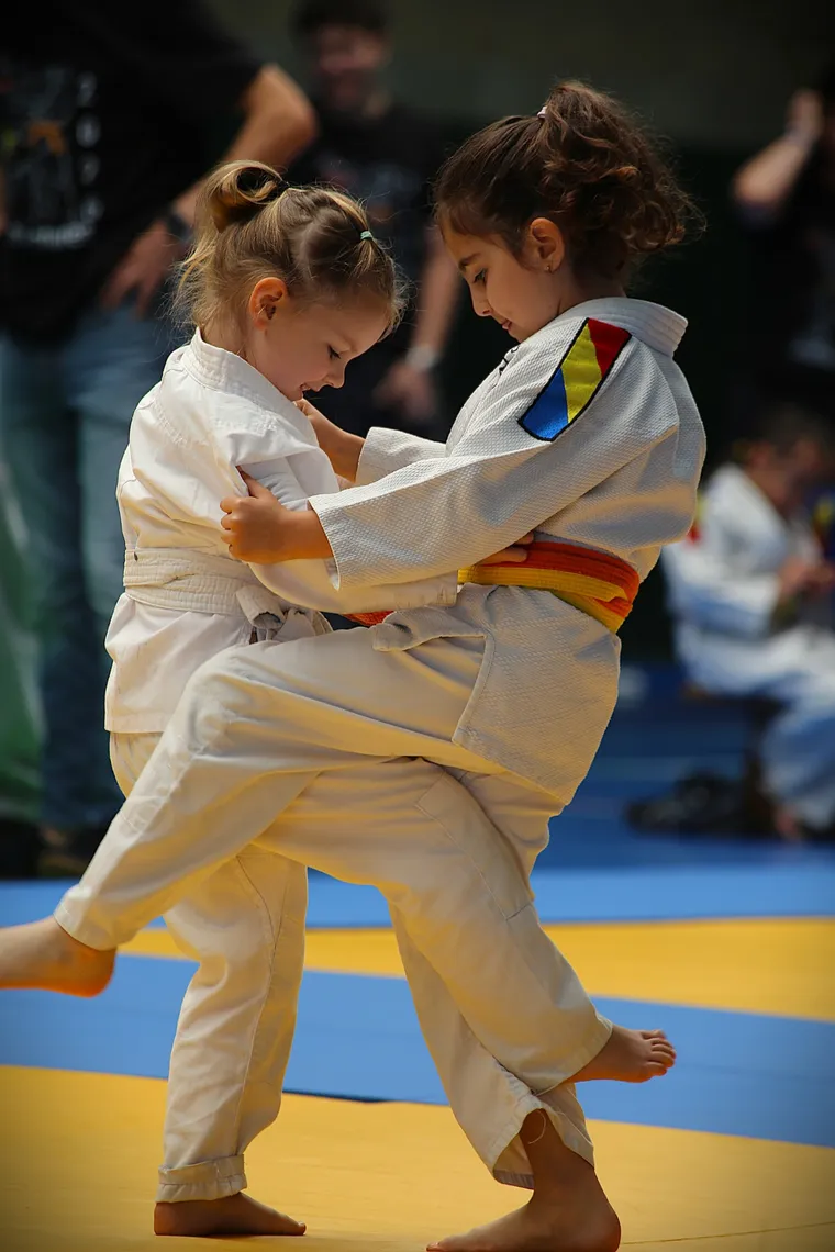 Dos niñas pequeñas sonríen mientras practican un agarre